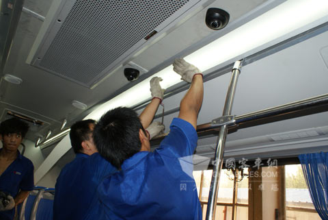工人們汗流浹背地為該批氣-電混合動力公交車鋪設燈管