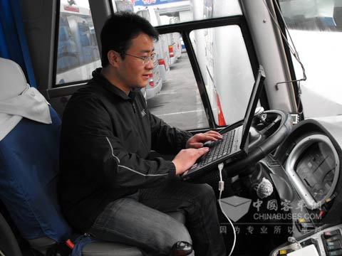 張海明在檢查客車發動機情況